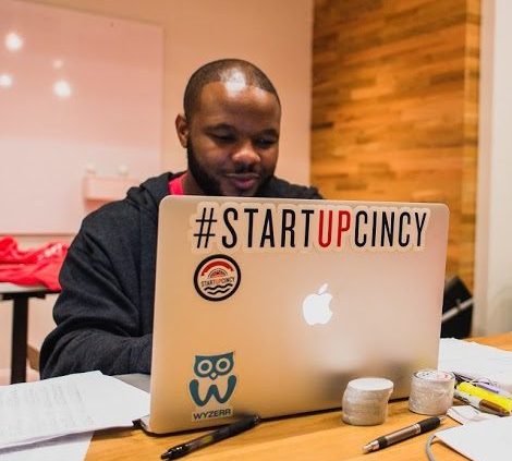 man working on computer with #startupcincy sticker