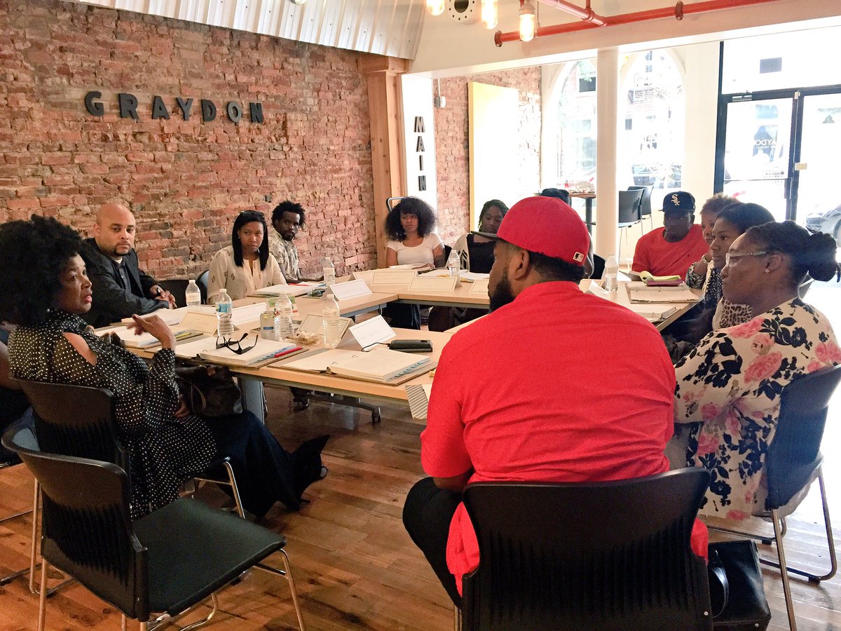 people meeting around a table in a brick office space talking about why cincinnati is a good place to live