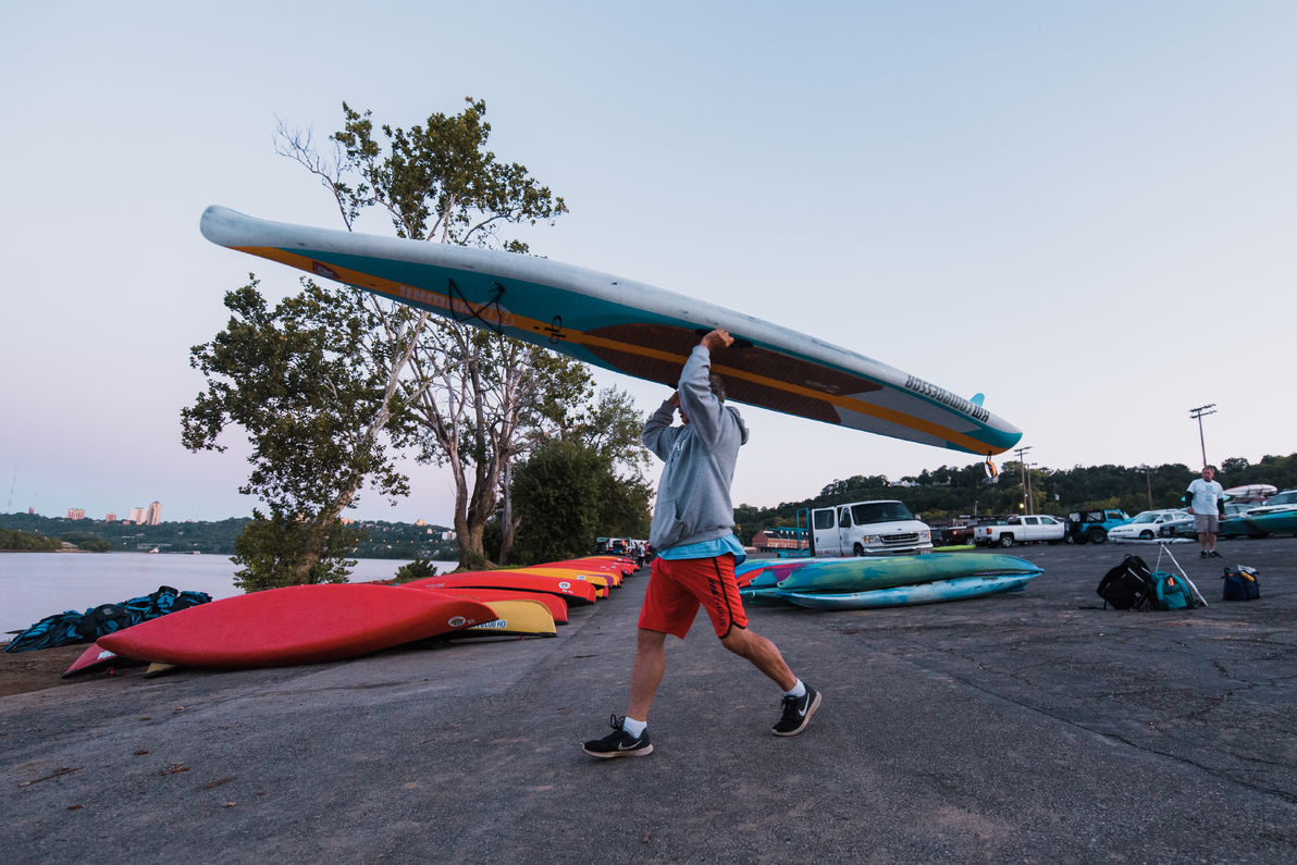 man carrying paddleboard overhead for Ohio River Paddlefest