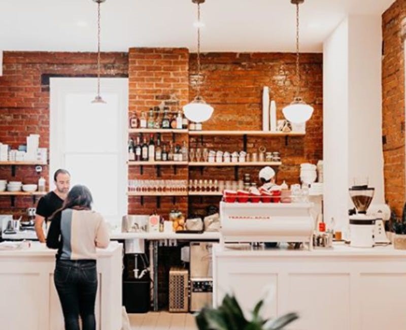 image of a woman paying for a coffee at bright coffee shop in camp washington 