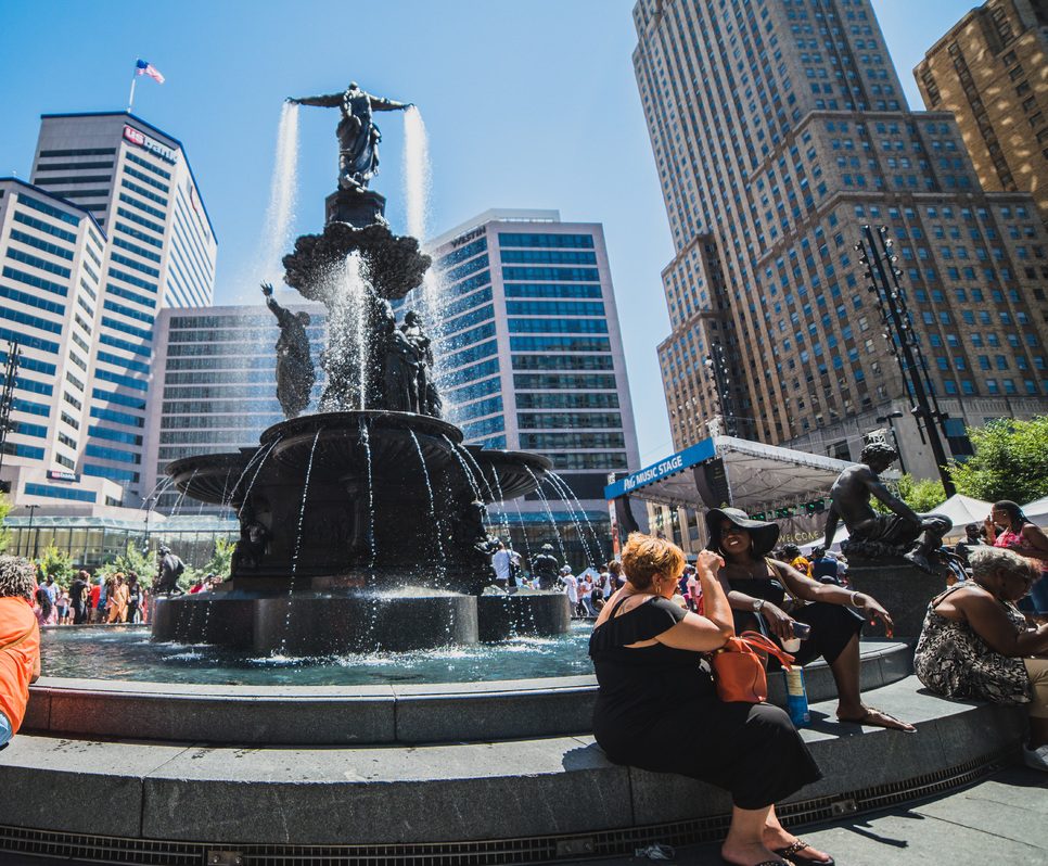 crowd sitting by the Genius of Water sculpture at Fountain Square